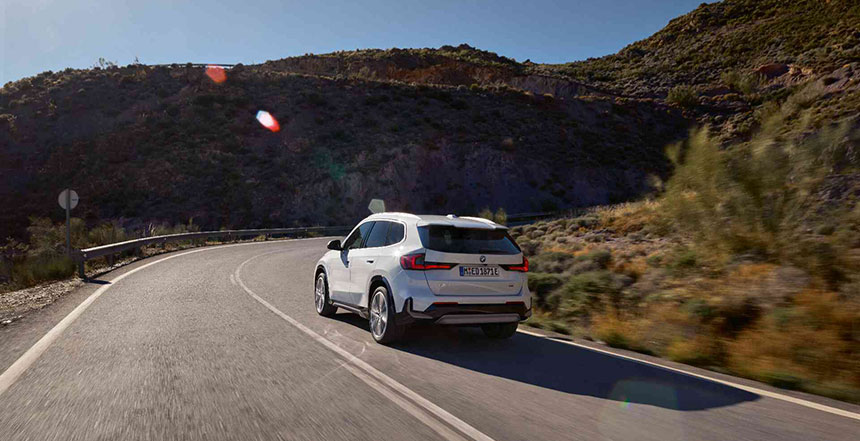 Ein weißer BMW iX1 auf einer Landstraße